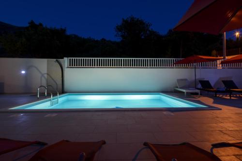 a swimming pool in a backyard at night at Villa Bingo in Cavtat