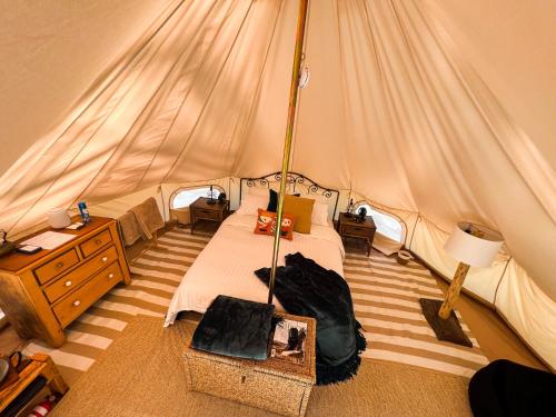 a bedroom with a bed in a tent at Golden Point Glamping in Faraday