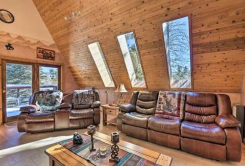 a living room with leather furniture in a cabin at Raven’s Nest Cabin with Glowing Bocce Ball Court in Angel Fire