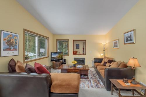 uma sala de estar com sofás e uma televisão em Suite Serenity Condo by NW Comfy Cabins em Leavenworth