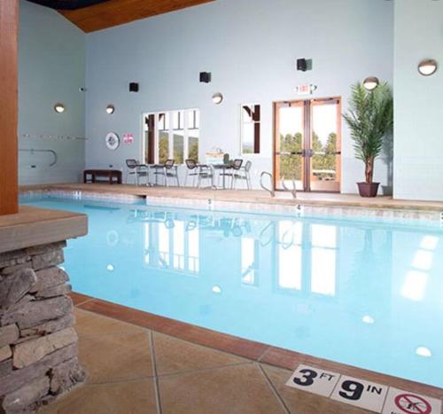 a large swimming pool with blue water in a building at Raven’s Nest Cabin with Glowing Bocce Ball Court in Angel Fire