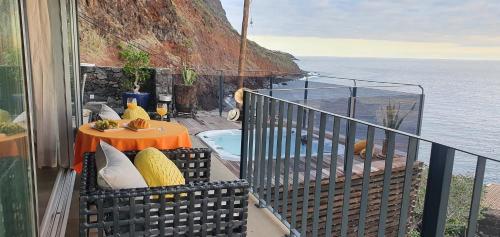 a balcony with a table and a view of the ocean at Casa da Rocha in Paul do Mar