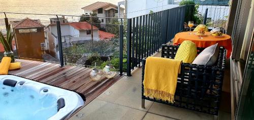 a balcony with a hot tub on a deck at Casa da Rocha in Paul do Mar