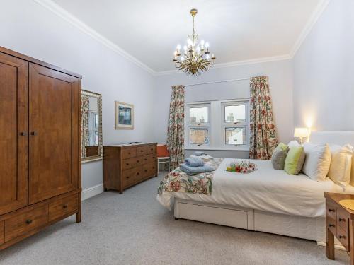 Schlafzimmer mit einem Bett, einer Kommode und Fenstern in der Unterkunft Laurel Villa in Cheltenham