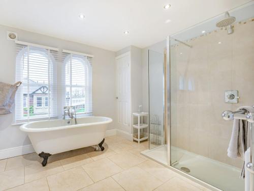 a bathroom with a tub and a glass shower at Laurel Villa in Cheltenham
