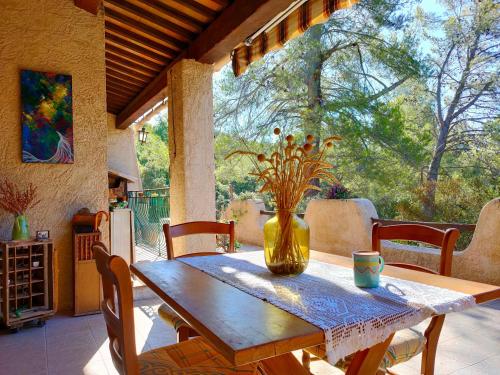 une table en bois avec un vase de fleurs. dans l'établissement Villa Les Chariotins, à Draguignan