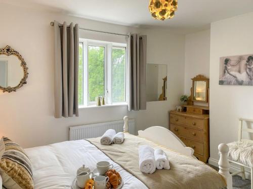 a bedroom with a bed with a tray of food on it at Mills Croft in Hognaston