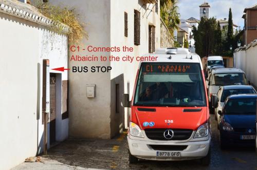 a bus parked next to a street with cars at Hotel Santa Isabel La Real in Granada