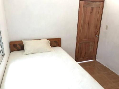 1 dormitorio con 1 cama y puerta de madera en LUGAR ENCANTADOR CON PATIO VEGETAL, 