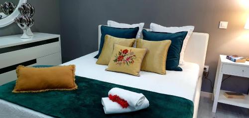 uma cama branca com almofadas coloridas em Casa da Rocha em Paul do Mar