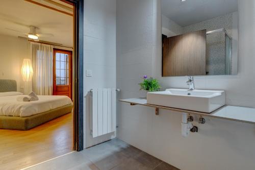 uma casa de banho com um lavatório e uma cama num quarto em Villa Oasis by SanSe Holidays em San Sebastián