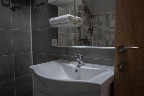 y baño con lavabo blanco y espejo. en Restoran Mijajlovic, en Kuršumlija