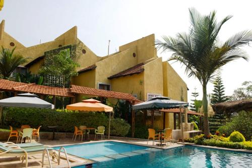 a resort with a swimming pool with chairs and umbrellas at Stipphotels, Kiyovu in Kigali