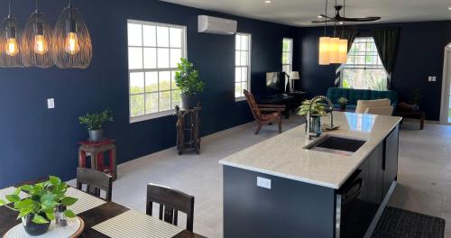 a kitchen and living room with blue walls at Sea Winds Bungalow - Tierra Del Sol Aruba in Noord