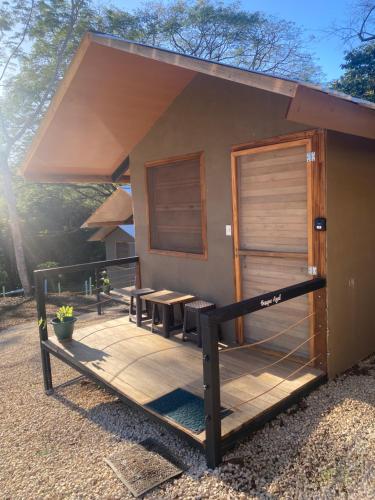 a building with a porch with a table and chairs at Cabañas del Bosque in Nandayure