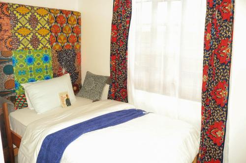 a small bedroom with a bed and a window at Wakanda@HeArt Stays in Kakamega