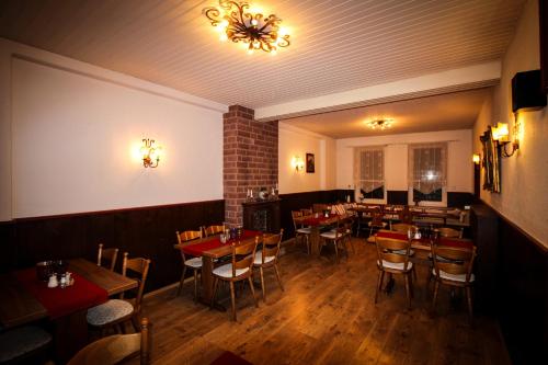 a dining room with tables and chairs in a restaurant at Hotel und Restaurant Zum Löwen in Gelnhausen
