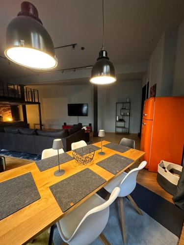 comedor con mesa de madera y sillas blancas en Loft mit privater Sauna en Heidelberg