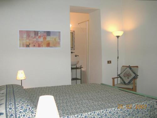 um quarto com uma cama, um candeeiro e uma cadeira em Umbria Valnerina in Noble Residence near Spoleto Apartment x 4-6 persons em SantʼAnatolia di Narco