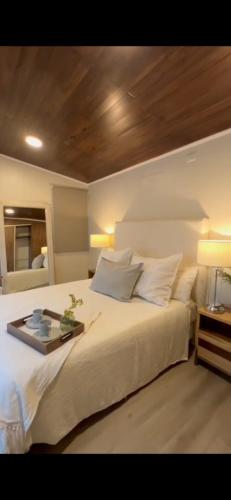 a bedroom with a white bed with a tray on it at La Canaria Casa de Campo in Colonia Caroya