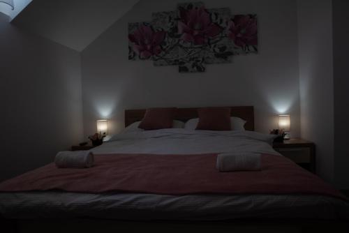 a bedroom with a large bed with two lamps at Restoran Mijajlovic in Kuršumlija