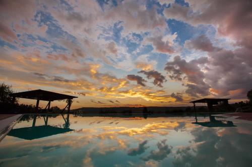 a reflection of the sky in a swimming pool with a sunset at Agriturismo La Vecchia Fattoria in Orte