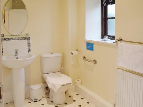 La salle de bains blanche est pourvue d'un lavabo et de toilettes. dans l'établissement The Stable, à High Halstow