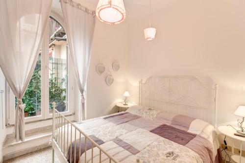 a white bedroom with a large bed and a window at Casa Dolce Casa in Rome