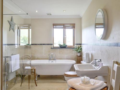 a bathroom with a tub and a sink at Maes Y Bryn Farmhouse in Llanwrda