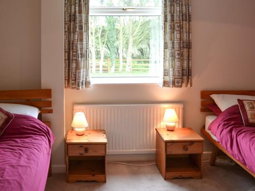 two twin beds in a room with a window at Tregoona in Crantock