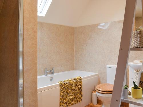 een badkamer met een bad en een toilet bij Fourwinds in Farlow