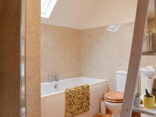 a bathroom with a bath tub and a toilet at Fourwinds in Farlow