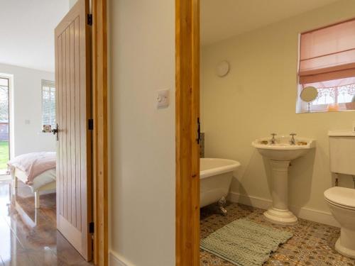 a bathroom with a sink and a toilet and a tub at Breckland Cottage in Hockwold cum Wilton