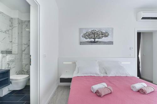- une chambre avec un lit rose et 2 serviettes dans l'établissement Villa Banovi with heated pool, à Knežević