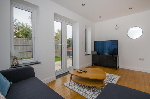 a living room with a couch and a table at Hideaway Cottage in Bristol