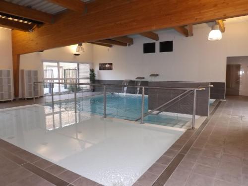 a swimming pool in a building with a glass floor at Résidence Les Rives de la Fecht - Colmar Ouest in Ingersheim