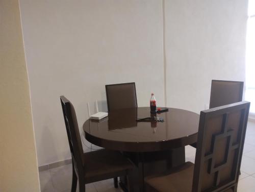 a dining room table with chairs and a bottle of soda on it at Torres casillas in Tonalá