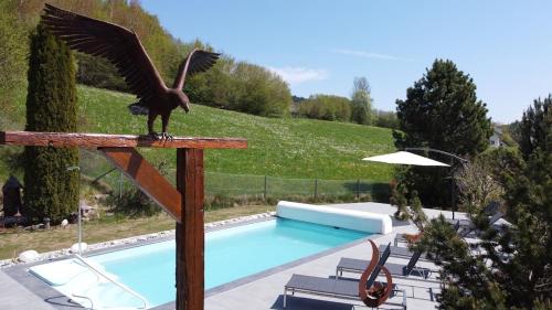 a statue of a bird standing on a rail next to a swimming pool at Ferienhaus Kraxlhütte Kärnten in Velden am Wörthersee