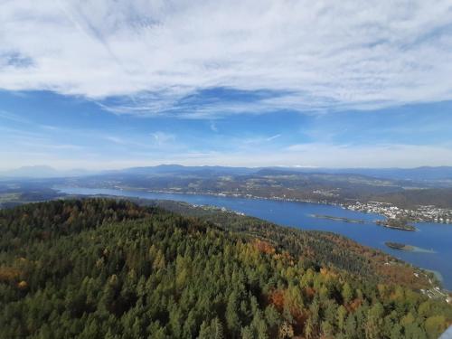 an aerial view of a lake with trees and a city at Ferienhaus Kraxlhütte Kärnten in Velden am Wörthersee