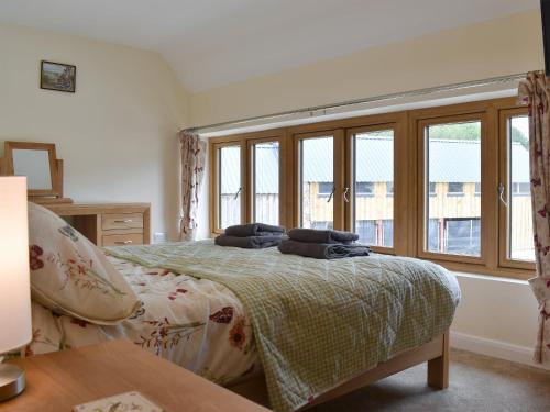 Un dormitorio con una cama con almohadas. en South Barn, en Monk Okehampton