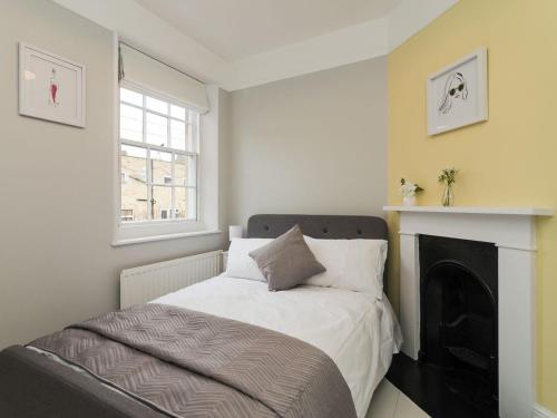 a small bedroom with a bed and a fireplace at Coastguard Retreat in Ramsgate