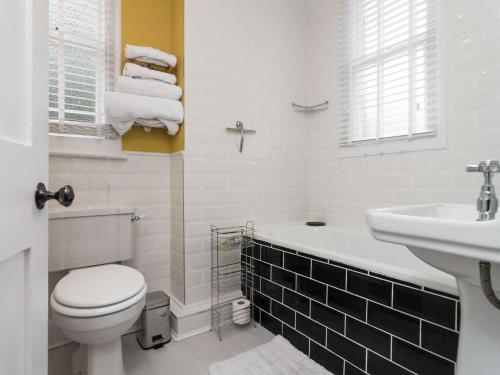 a white bathroom with a toilet and a sink at Coastguard Retreat in Ramsgate