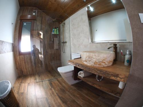 une salle de bain avec un lavabo, des toilettes et un miroir dans l'établissement EL Rincón de Lola, à Carboneras de Guadazaón