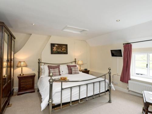 a bedroom with a bed and a window at Church Cottage in Islip