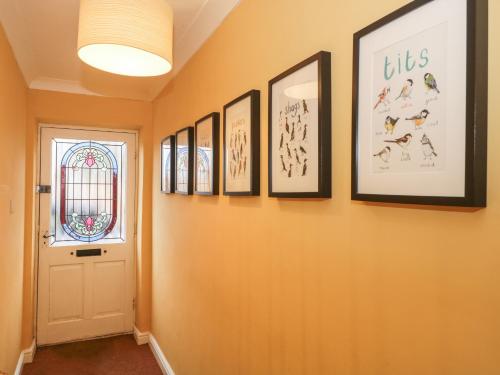 a hallway with pictures of dogs on the wall at Castle View Annex in Wareham
