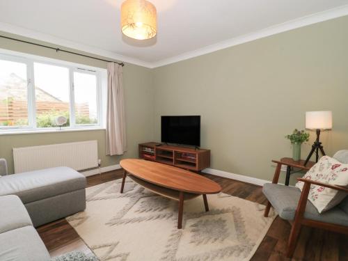 a living room with a table and a tv at Castle View Annex in Wareham