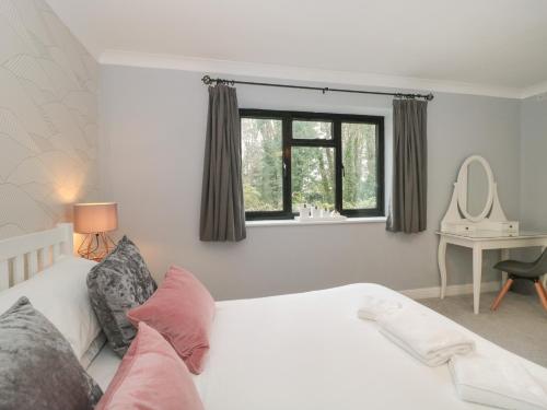 een slaapkamer met een wit bed en een raam bij Castle View Annex in Wareham