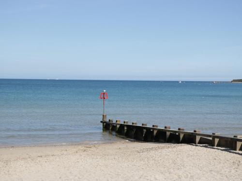 a pier on the beach with a red flag at Castle View Annex in Wareham