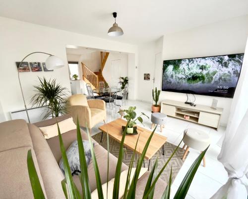 a living room with a couch and a table at Location maison Jardin Gîte Angers Les Ponts de Cé in Les Ponts-de-Cé