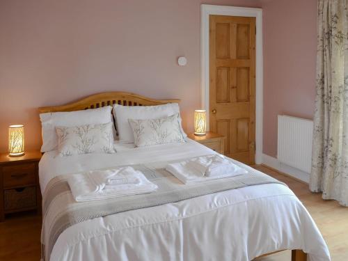 a bedroom with a white bed with two towels on it at Rockhill in Inverness